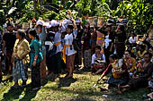 Cremation ceremony - The villagers line up, each with something to carry: holy water, ritual accessories, pyramids of food offerings piled high on their heads. 