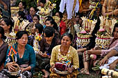 Cremation ceremony - The villagers line up, each with something to carry: holy water, ritual accessories, pyramids of food offerings piled high on their heads. 