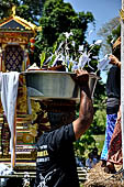 Cremation ceremony - The villagers line up, each with something to carry: holy water, ritual accessories, pyramids of food offerings piled high on their heads.