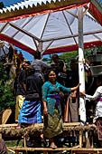 Cremation ceremony - Family members then passes ritual items up to be placed on the coffin.
