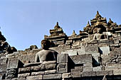 Borobudur - Buddha statues set in its own niche and pinnacles atop the balustrades of the lower four terraces. 