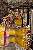 Dambulla cave temples - Cave 5, Devana Alut Viharaya (Second New Temple). On the wall behind Buddha feet the paintings of a dark Vishnu flanked by Kataragama with his peacock and Bandara (a local deity). 