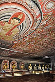 Dambulla cave temples - Cave 2, Maharaja Vihara (Temple of the Great Kings) panels of the Mara Parajaya (Defeat of Mara): the third panel shows the Isipatana: Buddha seated in the vitarka mudra gives the first sermon to an assembly of gods. 