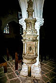 Il complesso parrocchiale, enclos, di La Martyre. Acquasantiera della chiesa di Saint-Salomon: un angelo regge gli aspersori, in alto San Michele che uccide il drago.