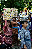 Cremation ceremony - The villagers line up, each with something to carry: holy water, ritual accessories, pyramids of food offerings piled high on their heads.