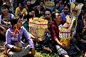Cremation ceremony - The villagers line up, each with something to carry: holy water, ritual accessories, pyramids of food offerings piled high on their heads.