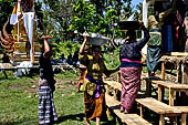 Cremation ceremony - Family members then passes ritual items up to be placed on the coffin. 