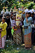 Cremation ceremony - The villagers line up, each with something to carry: holy water, ritual accessories, pyramids of food offerings piled high on their heads.