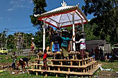 Cremation ceremony - Family members then passes ritual items up to be placed on the coffin. 