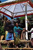 Cremation ceremony - Family members then passes ritual items up to be placed on the coffin. 