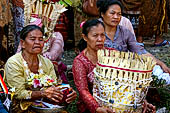 Cremation ceremony - The villagers line up, each with something to carry: holy water, ritual accessories, pyramids of food offerings piled high on their heads. 