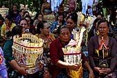 Cremation ceremony - The villagers line up, each with something to carry: holy water, ritual accessories, pyramids of food offerings piled high on their heads. 