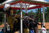 Cremation ceremony - Family members then passes ritual items up to be placed on the coffin. 