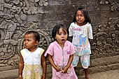 Pura Meduwe Karang - Bali - Little girls attracting tourist tips in front of the temple bas-reliefs.