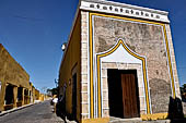 Izamal - low Spanish colonial houses, most of the buildings facades are painted a glowing ochre colour.