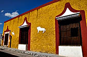 Izamal - low Spanish colonial houses, most of the buildings facades are painted a glowing ochre colour.