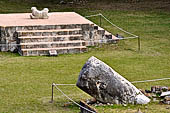Uxmal - Palace of the Governor. Terrace on top of the Palace Platform, the fallen monolith called 'la Picota' with in the  background a platform with a two-headed Jaguar Throne. 