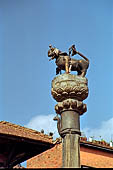 Bhaktapur - Tachupal Tole. Bhimsen Temple. The brass lion on a pillar standing in front of the temple.
