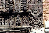Changu Narayan - Detail of carved wooden figures (Krishna playing the flute) on the pilgrim rest houses surrounding the temple courtyard.