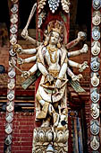 Changu Narayan - Roof strut of first level (North facade). The wooden sculpture represents a ten armed Rama, the sixth avatar of Vishnu. The deity is pointing his arch towards a small figure.