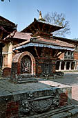 Changu Narayan - Platform of a former temple with on top a stele with LaksmiNarayan (visible side) and  Vishnu Vishworup (on the opposite side), on the background the small two storied pagoda Kileshwor temple.