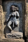 Hirapur - the Sixtyfour Yoginis Temple, Yogini n 2 (clockwise), two armed standing on a corpse. Note the various ornaments for the head and the ears. 