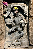Hirapur - the Sixtyfour Yoginis Temple, Yogini n 56 (clockwise) Chamunda, four armed skeletal figure raising a lion over the head. She has a garland of skulls and with the lower hand hold a severed human head. In the pedestal a musk deer. 