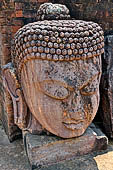 Ratnagiri - The courtyard of the main monastery. Imposing head of Buddha Tathagata (8th c.)