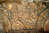 Udaigiri Cave 1  Rani Gumpha Queen's Cave - decorations of the three doorways of the veranda of the left wing of the ground floor. The second tableau (from left) a seated man between two women and  other two women holding offerings 