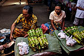 The market of Makale - stalls selling local produce including coffee, tobacco, buckets of live eels, piles of fresh and dried fish, and jugs of  'balok'