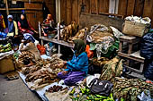 The market of Makale - stalls selling local produce including coffee, tobacco, buckets of live eels, piles of fresh and dried fish, and jugs of  'balok'
