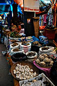 The market of Makale - stalls selling local produce including coffee, tobacco, buckets of live eels, piles of fresh and dried fish, and jugs of  'balok'