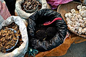 The market of Makale - stalls selling local produce including coffee, tobacco, buckets of live eels, piles of fresh and dried fish, and jugs of  'balok'
