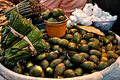 The market of Makale - stalls selling local produce including coffee, tobacco, buckets of live eels, piles of fresh and dried fish, and jugs of  'balok'