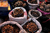 The market of Makale - stalls selling local produce including coffee, tobacco, buckets of live eels, piles of fresh and dried fish, and jugs of  'balok'