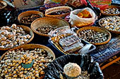 The market of Makale - stalls selling local produce including coffee, tobacco, buckets of live eels, piles of fresh and dried fish, and jugs of  'balok'