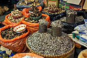 The market of Makale - stalls selling local produce including coffee, tobacco, buckets of live eels, piles of fresh and dried fish, and jugs of  'balok'