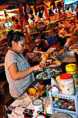 The market of Makale - stalls selling local produce including coffee, tobacco, buckets of live eels, piles of fresh and dried fish, and jugs of  'balok' 