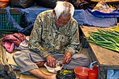 The market of Makale - stalls selling local produce including coffee, tobacco, buckets of live eels, piles of fresh and dried fish, and jugs of  'balok' 