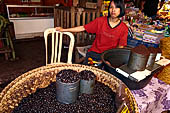 The market of Makale - stalls selling local produce including coffee, tobacco, buckets of live eels, piles of fresh and dried fish, and jugs of  'balok' 