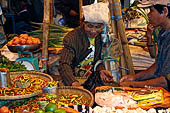 The market of Makale - stalls selling local produce including coffee, tobacco, buckets of live eels, piles of fresh and dried fish, and jugs of  'balok' 
