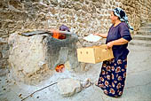 Mardin, donna che cuoce il pane tradizionale in un forno di terracotta interrato chiamato tonir. 